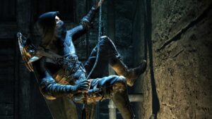 Thief immersive sim gameplay featuring hooded assassin climbing a rope on a stone wall in the dark