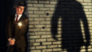 L.A. Noire – detective Cole Phelps hides by a brick wall, gun in hand, as a suspect’s shadow looms nearby.