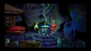 Guybrush Threepwood speaks with the voodoo priestess over a glowing cauldron in The Secret of Monkey Island.