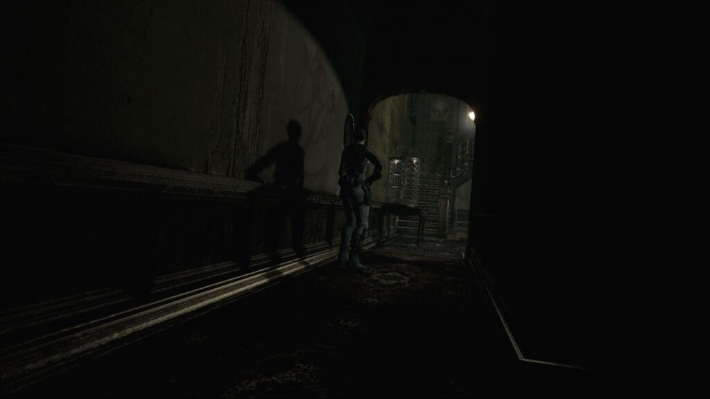 Jill Valentine moving through a dark mansion corridor in Resident Evil HD Remaster